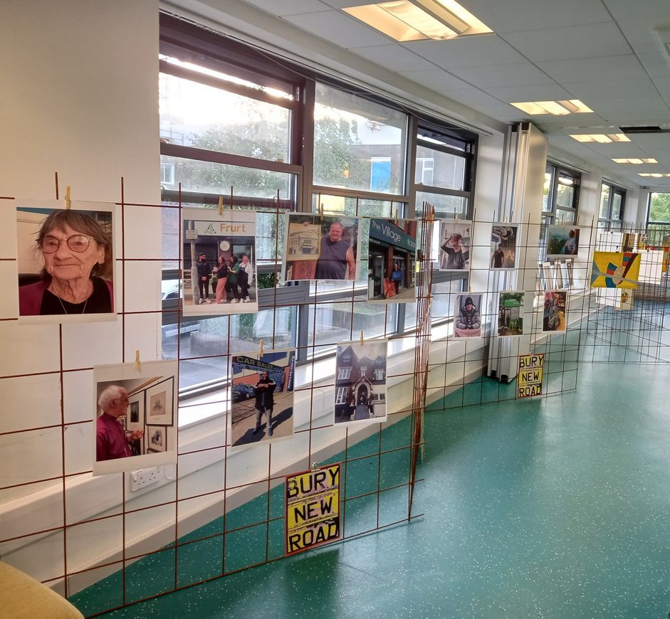 Wall display of portrait photographs from the Bury New Road exhibition