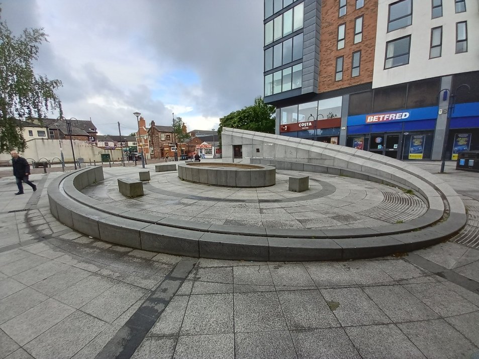 The curved stone bench and fountain in Prestwich town centre that inspired one of The Fed Mental Wellbeing Group's Prestwich Palette rubbings