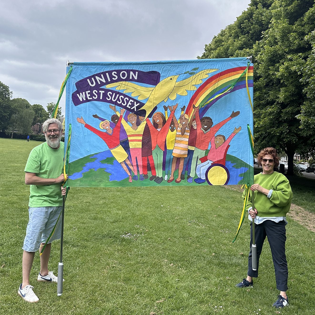 Hand-painted Unison West Sussex banner featuring a dove, a rainbow and a group of figures
