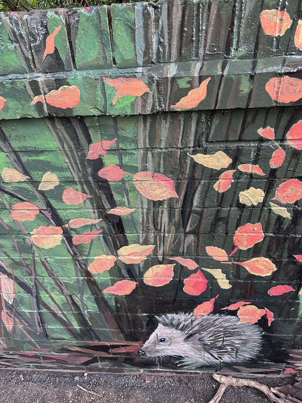 Detail of a hedgehog among falling autumn leaves