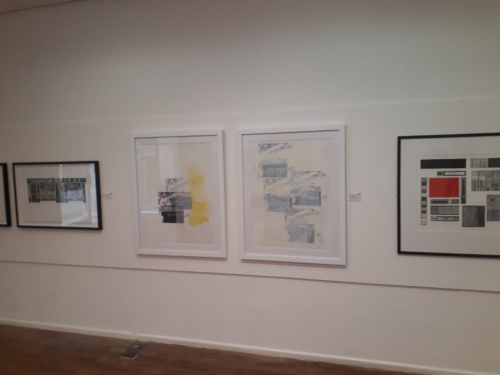 A gallery wall of framed prints and collages, including a shopfront collage and abstract geometric pieces, at Flourish: Excellence in Printmaking, Woodend Gallery, Scarborough