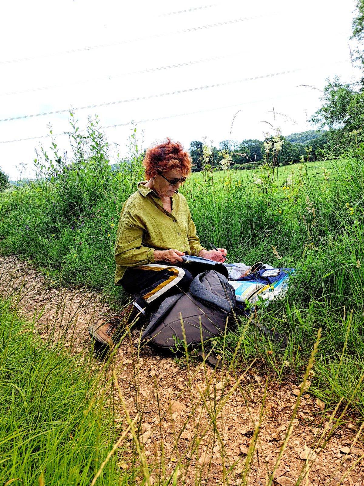 Louise Garman sketching outdoors in a wildflower meadow