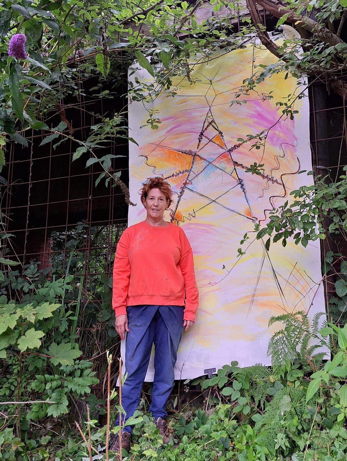 Louise Garman standing beside one of her large hand-painted fabric works