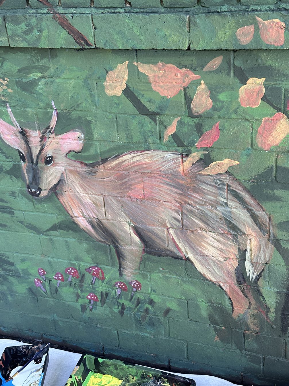 Detail of the deer among autumn leaves and toadstools
