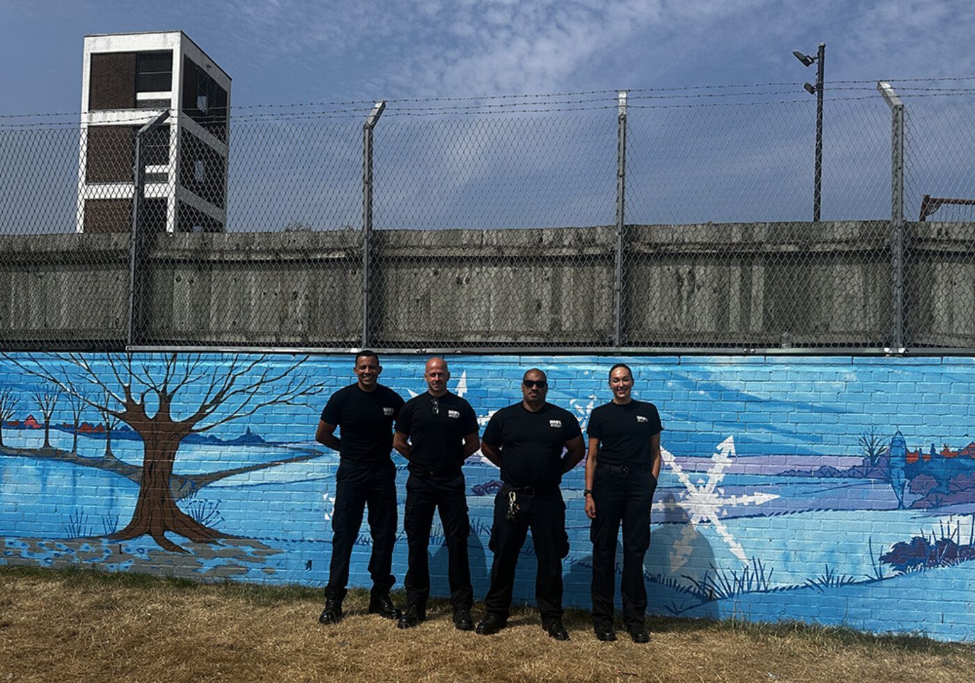 Fire station staff in front of the winter mural