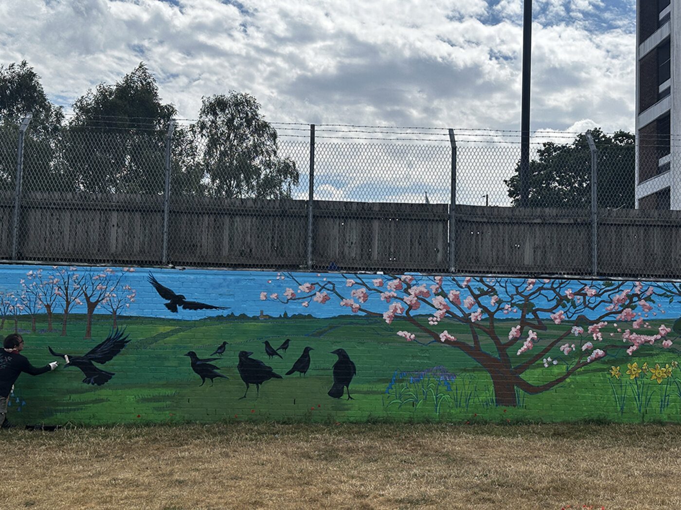 Louise Garman painting the crows section of the mural