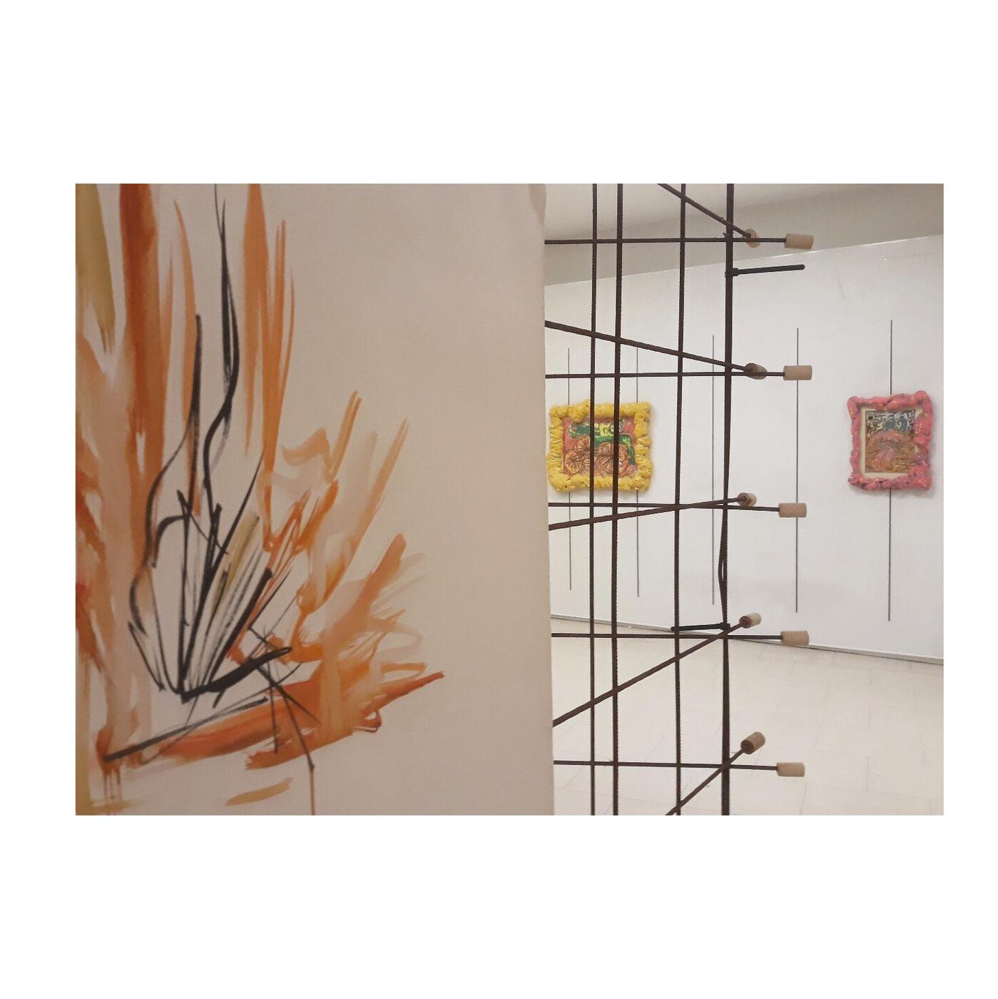 Gallery installation with wire grid sculpture and framed collage works